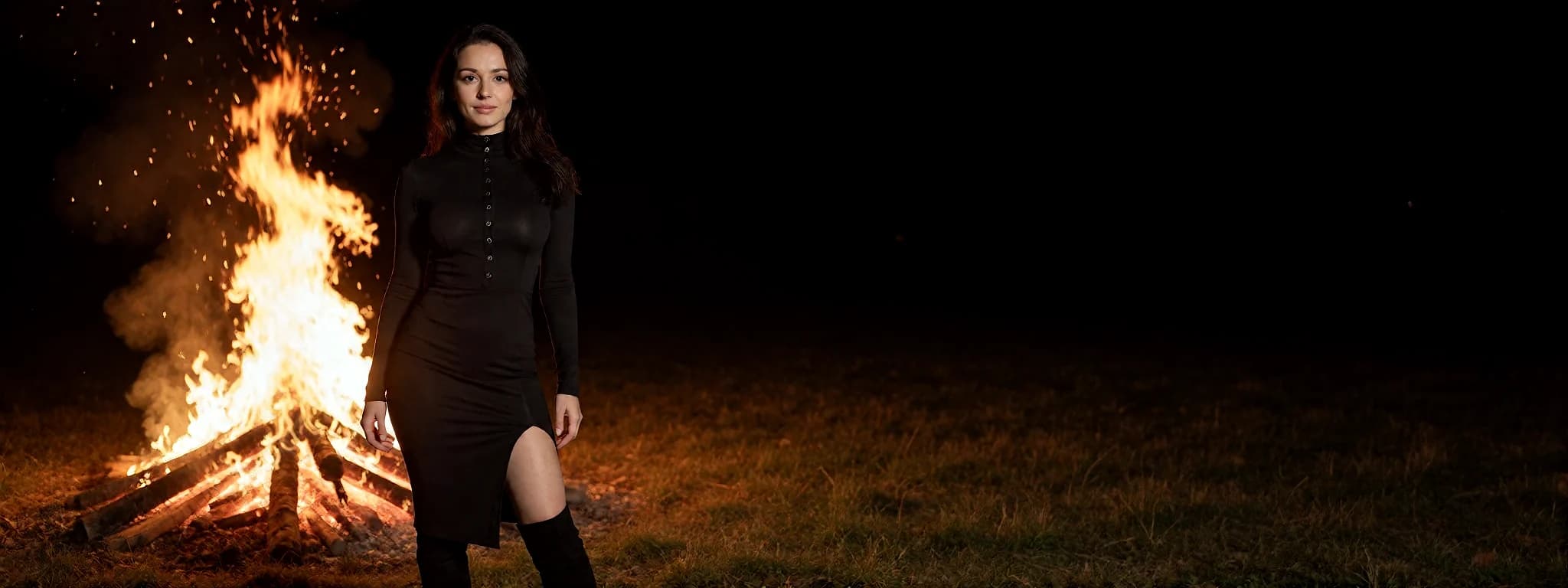 An AI Girlfriend character standing beside a bonfire at night